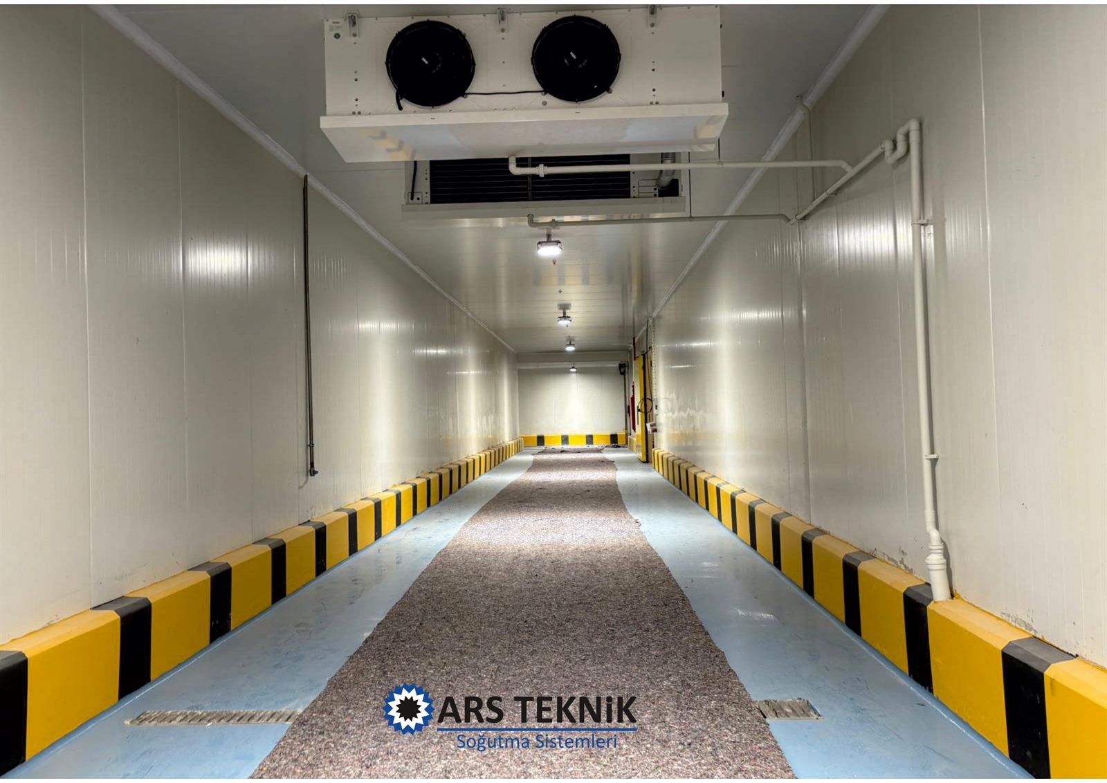 Cold-room interior with insulated panels and an overhead cooling unit.